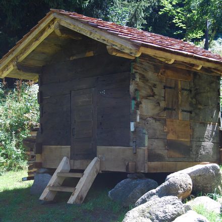 A tiny wooden cabin with closed shutters.