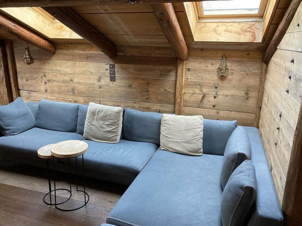 A blue corner sofa in front of wooden walls and ceilings.