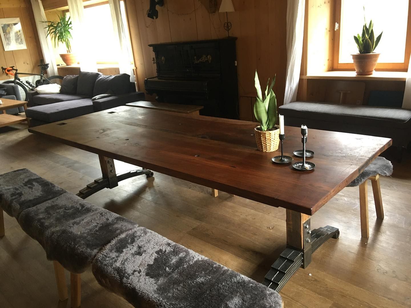 A dark brown wooden table using old train springs as feet.