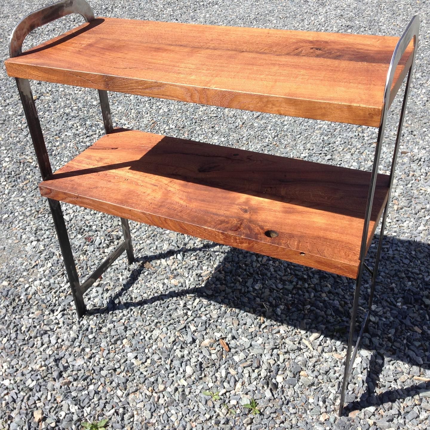 Two wooden shelves kept together by U-shaped metal beams on each side..